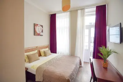a bedroom with a bed and a desk and a window at Elegant & Stylish Center Apartments! in Prague