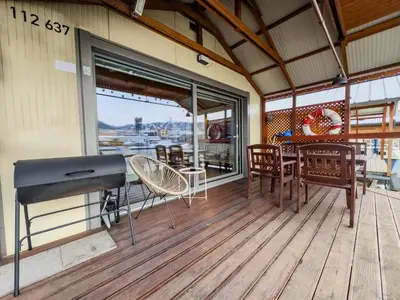a grill on a deck with a table and chairs at Houseboat Franklin - Houseboats Benjamin & Franklin in Prague