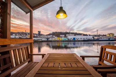 a porch with a table and chairs on a body of water at Houseboat Franklin - Houseboats Benjamin & Franklin in Prague