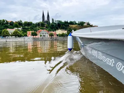 a boat in the water with a city in the background at Houseboat Franklin - Houseboats Benjamin & Franklin in Prague