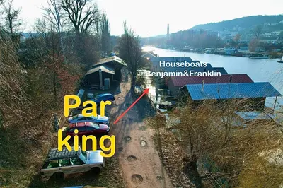 a truck driving down a dirt road next to a train at Houseboat Franklin - Houseboats Benjamin & Franklin in Prague