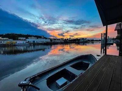 a boat is docked at a dock with a sunset at Houseboat Benjamin - Houseboats Benjamin & Franklin in Prague
