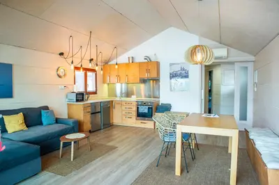 a kitchen and living room with a blue couch and a table at Houseboat Benjamin - Houseboats Benjamin & Franklin in Prague