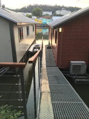 a walkway between two buildings next to a body of water at Houseboat Benjamin - Houseboats Benjamin & Franklin in Prague
