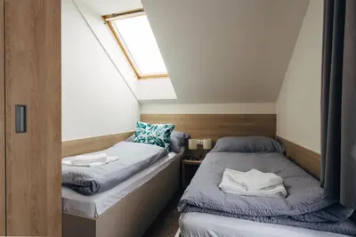 two beds in a small room with a window at Ubytování Kytín in Kytín