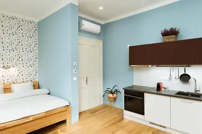 a bedroom with blue walls and a bed and a kitchen at Dream blue in city centreWenceslas Sq in walk in Prague