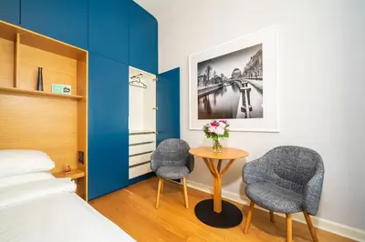 a bedroom with a bed and two chairs and a table at Quiet city center apartment in hip & foodie area in Prague