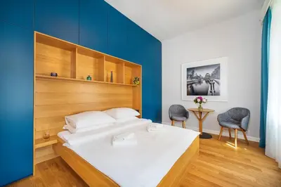 a bedroom with a bed with a blue wall at Quiet city center apartment in hip & foodie area in Prague