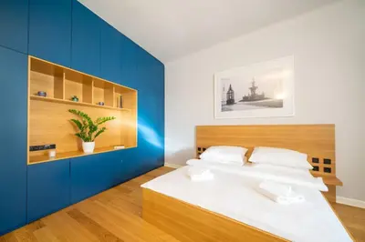 a bedroom with a bed with a blue accent wall at Quiet city center apartment in hip & foodie area in Prague