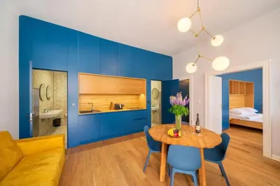 a living room with a table and a blue wall at Quiet city center apartment in hip & foodie area in Prague