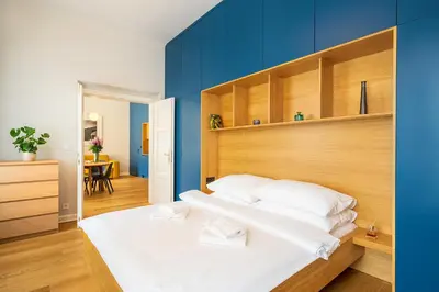 a bedroom with a white bed with a blue wall at Quiet city center apartment in hip & foodie area in Prague