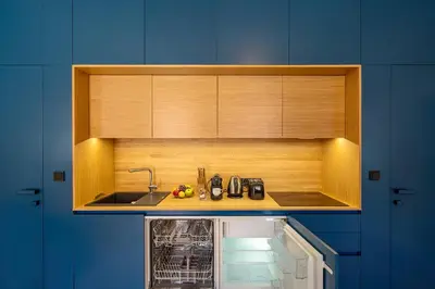 a kitchen with a sink and wooden cabinets at Quiet city center apartment in hip & foodie area in Prague