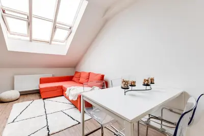 a living room with a white table and a red couch at Central Cool Apt with terrace - Leg11 in Prague