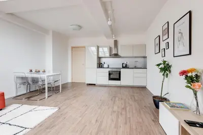 a living room with a kitchen and a dining table at Central Cool Apt with terrace - Leg11 in Prague