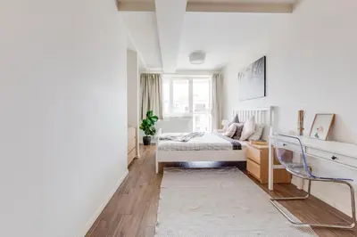 a bedroom with a bed and a desk and a window at Central Cool Apt with terrace - Leg11 in Prague