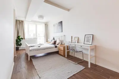 a white bedroom with a bed and a desk at Central Cool Apt with terrace - Leg11 in Prague
