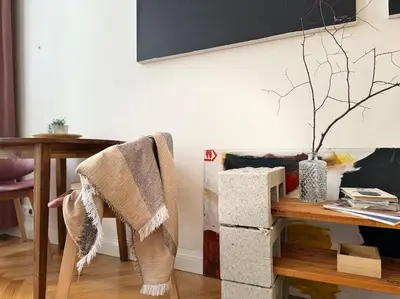 a living room with a table and a chair with a rug at Chic Prague Apartment in Prague