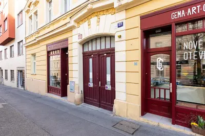 a building with red doors on a street at Modern Attic with Terrace - machova in Prague
