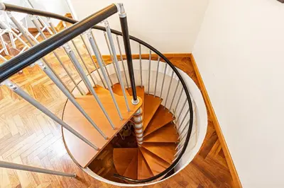 a spiral staircase with a metal railing at Modern Attic with Terrace - machova in Prague