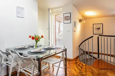 a dining room table with a vase of flowers on it at Modern Attic with Terrace - machova in Prague