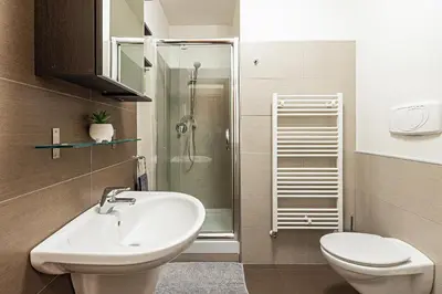 a bathroom with a sink and a toilet and a shower at Modern Attic with Terrace - machova in Prague