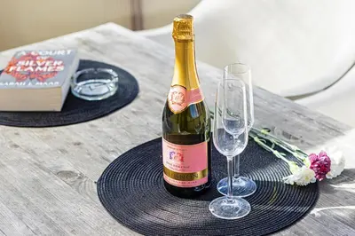 a bottle of wine sitting on a table with two glasses at Modern Attic with Terrace - machova in Prague
