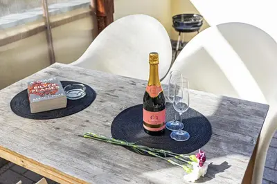 a bottle of wine and glasses on a table at Modern Attic with Terrace - machova in Prague