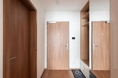 two wooden doors in a room with wooden floors at Luxury & air-conditioned Osko Apartment near the city center in Prague