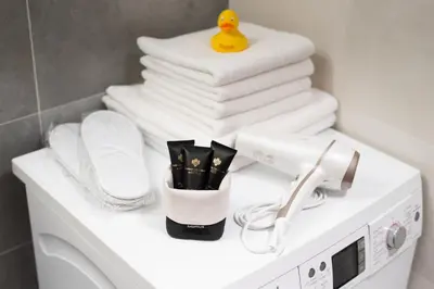 a pile of towels and a rubber duck on top of a washing machine at Luxury & air-conditioned Osko Apartment near the city center in Prague
