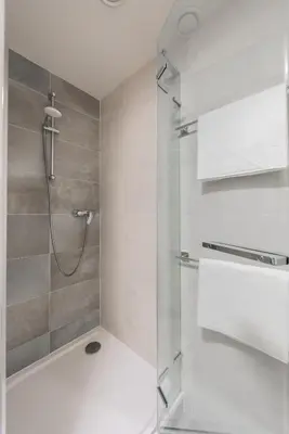 a bathroom with a shower with a glass door at Luxury & air-conditioned Osko Apartment near the city center in Prague
