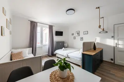 a small room with a bed and a table and chairs at Bellagio Apartment in Prague