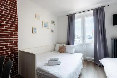 a small bedroom with a bed and a window at Bellagio Apartment in Prague