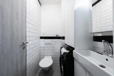 a white bathroom with a toilet and a sink at Bellagio Apartment in Prague