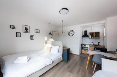 a bedroom with a bed and a desk and a kitchen at Bellagio Apartment in Prague