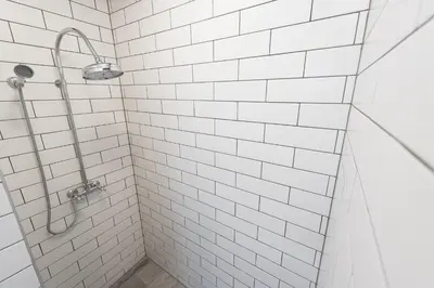 a white tiled shower in a white bathroom at Bellagio Apartment in Prague