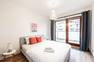 a white bedroom with a large bed and a window at Diamond River in Prague