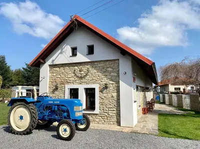 a tractor parked in front of a small building at Historická chalupa Lhotky 1844 - soukromí a klid u Sázavy in Malotice
