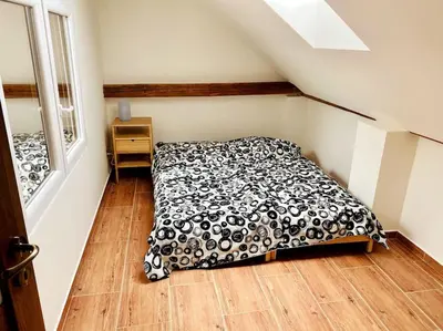 a bedroom with a bed with a black and white comforter at Historická chalupa Lhotky 1844 - soukromí a klid u Sázavy in Malotice