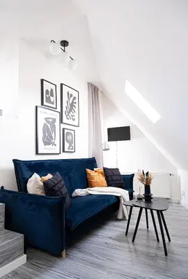 a living room with a blue couch and a table at Rentero Artsy Roof Top Apartment in City Centre in Prague
