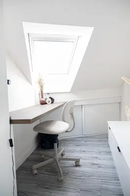a desk and a chair in a room with a window at Rentero Artsy Roof Top Apartment in City Centre in Prague