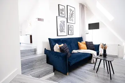 a living room with a blue couch and a table at Rentero Artsy Roof Top Apartment in City Centre in Prague