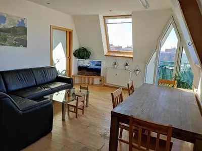 a living room with a black couch and a table at Very comfortable flat for the whole family in Prague