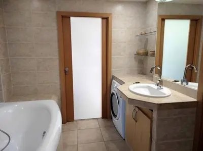 a bathroom with a tub sink and a washing machine at Very comfortable flat for the whole family in Prague