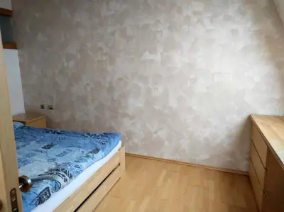 a small bedroom with a bed and a wall at Very comfortable flat for the whole family in Prague