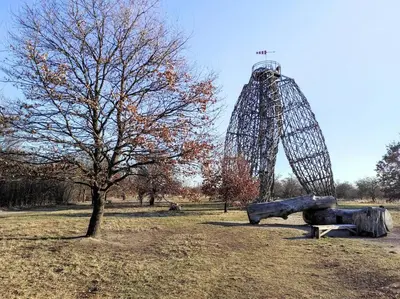a tree in a field with a tower in the background at Very comfortable flat for the whole family in Prague