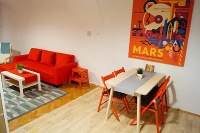 a living room with a red couch and a table and chairs at U Koniáše in Litoměřice
