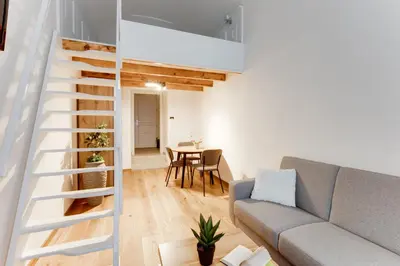 a living room with a couch and a staircase at Dream Apartments Prague in Prague