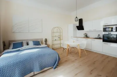 a kitchen with white cabinets and a table and chairs at 7th Heaven Apartment close to metro and center in Prague
