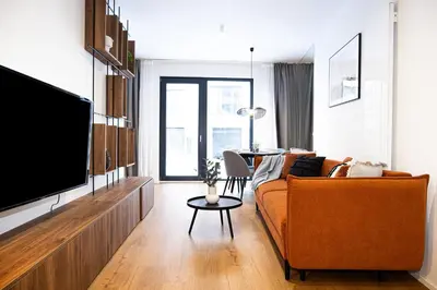 a bed with two pairs of slippers on it at Rentero Scandinavian - Private Garden APT in Prague