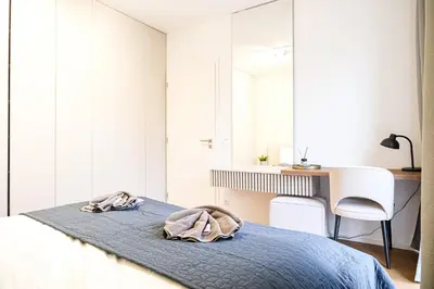 a bedroom with a bed and a desk and a chair at Rentero Michelska Residence Scandinavian Quiet Apartment, Prague in Prague